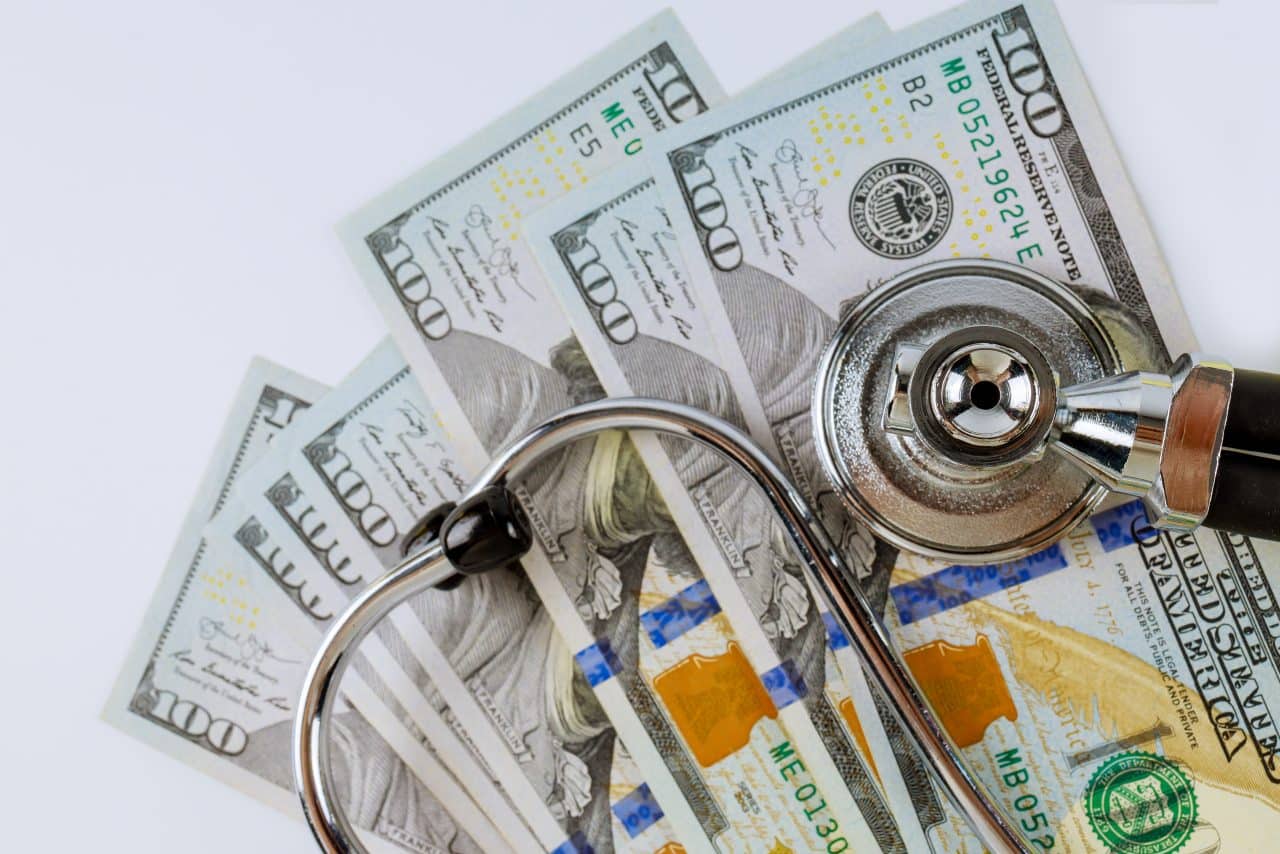 Stethoscope in US dollar bills on medical costs healthcare payment of paid medicine.