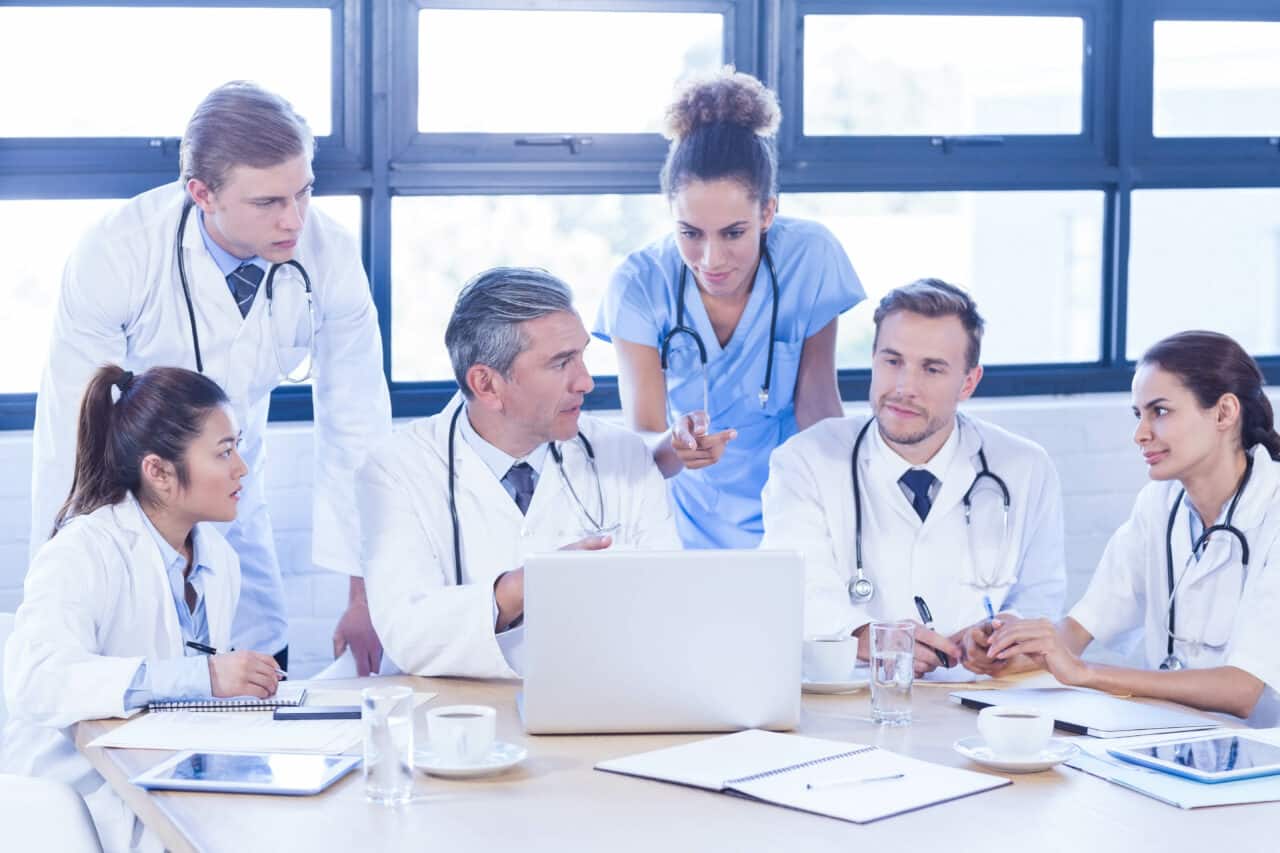 Medical team looking into laptop and having a discussion at conference room